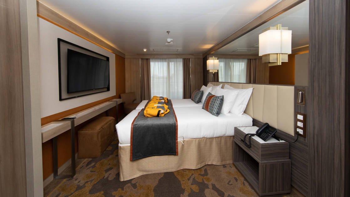 Deluxe Suite aboard World Explorer with double bed, 2 parkas, TV and balcony.