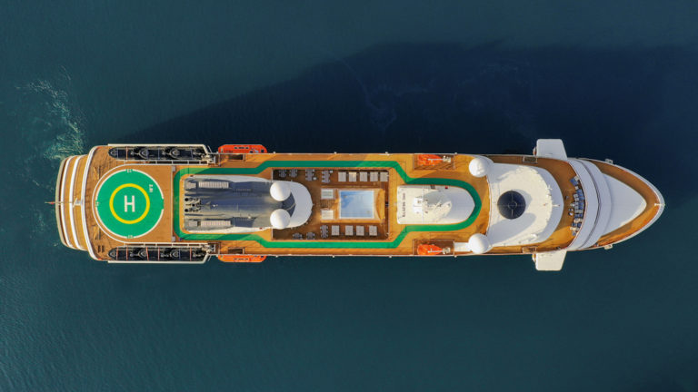 Aerial drone photo of top deck of World Explorer polar small ship with helicopter pad, pool & running track.