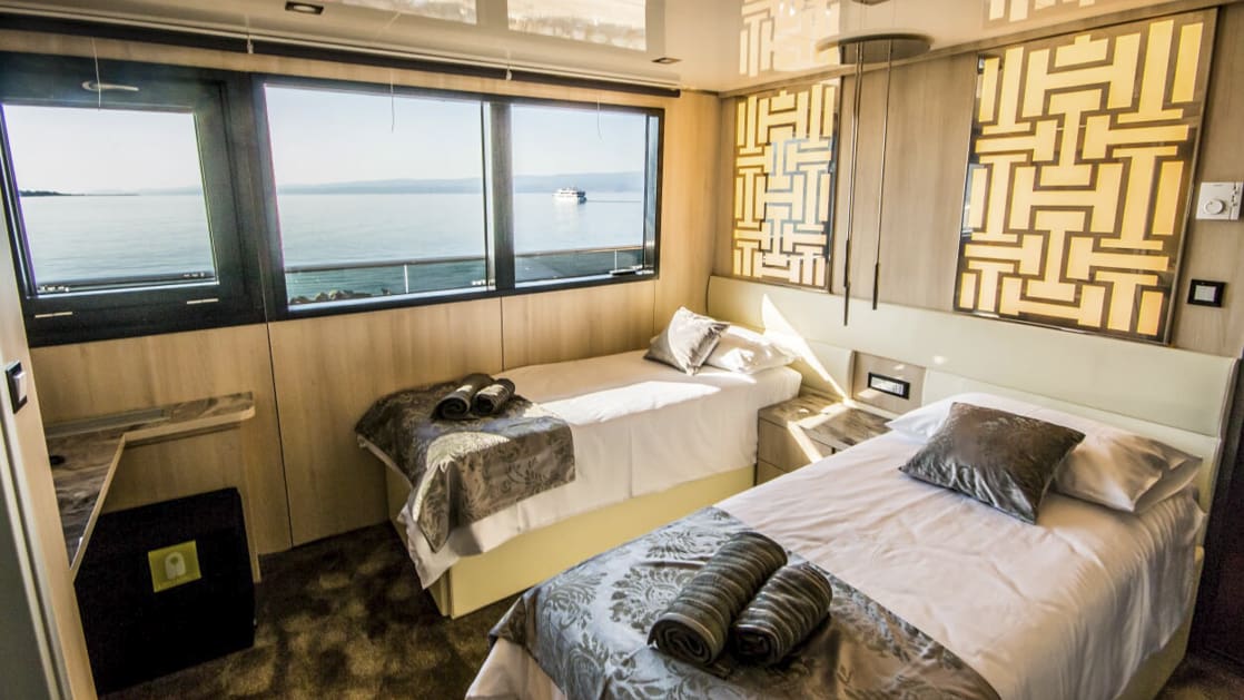 Main Deck Cabin aboard Black Swan with two twin beds and large windows.