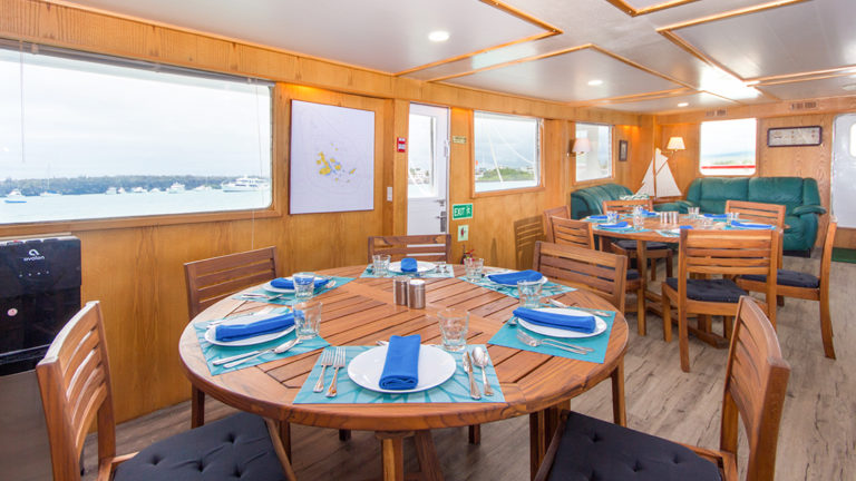 Set tables in dining room by lounge aboard Cachalote Explorer.