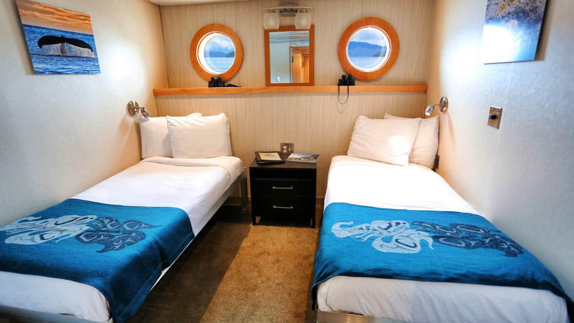 Category A stateroom aboard Chichagof Dream with two twin beds and two portholes.