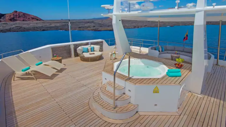Social area on top deck aboard Alya with hot tub and lounge chairs.