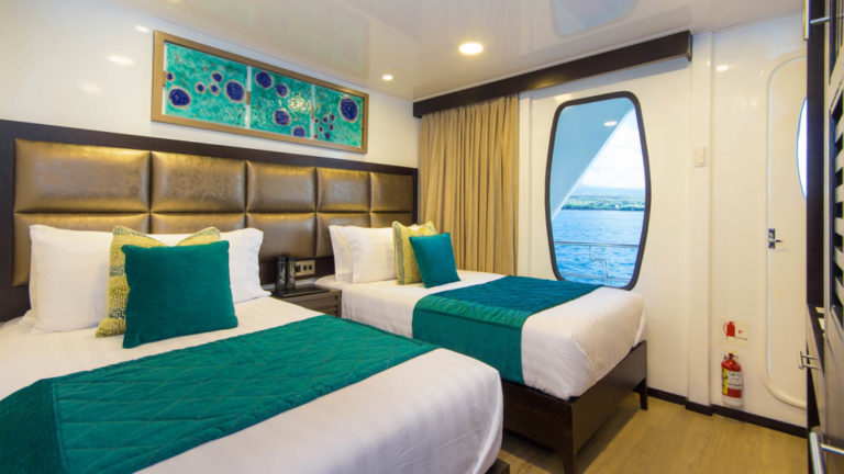 Twin Cabin aboard Alya with two single beds, window, and entry door.