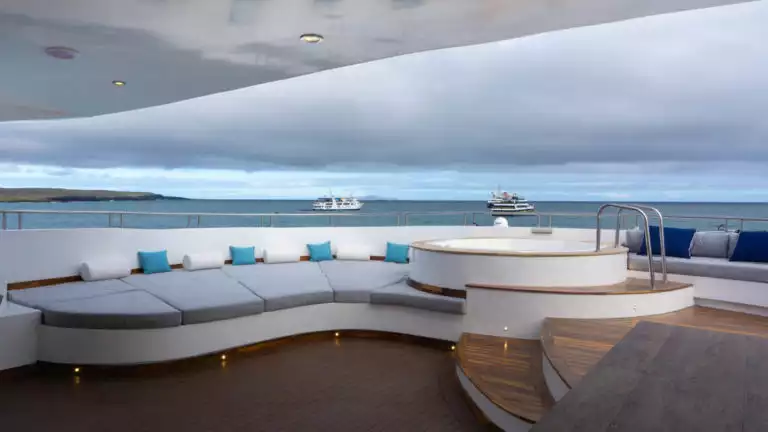 Galapagos Infinity outdoor sun deck with large lounge area and hot tub.