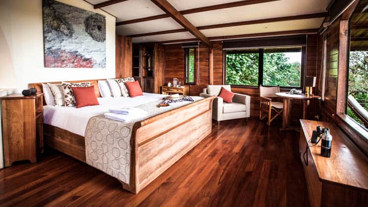 Master bedroom of Family Villa at Galapagos Safari Camp Santa Cruz Highlands in the Galapagos Islands with king bed & wood floor.