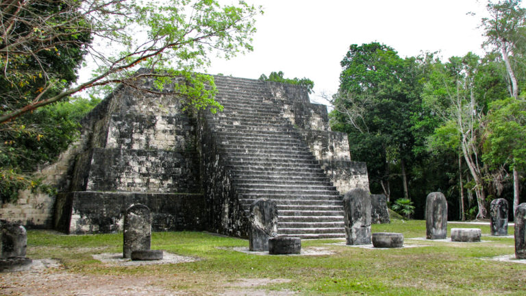 A pyramid in Tikal with many steps to a flat platform.