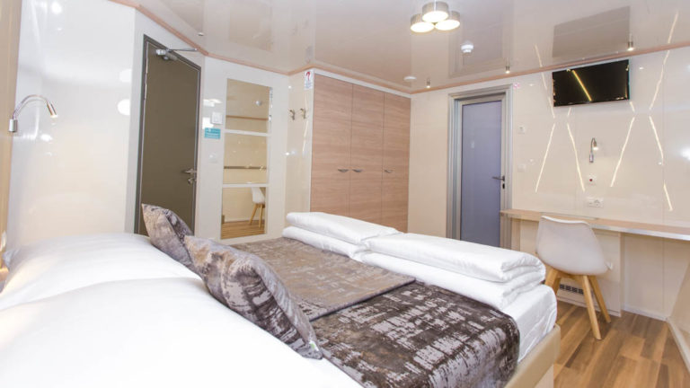 Maritimo stateroom with double bed, bathroom, closet, desk and seating.