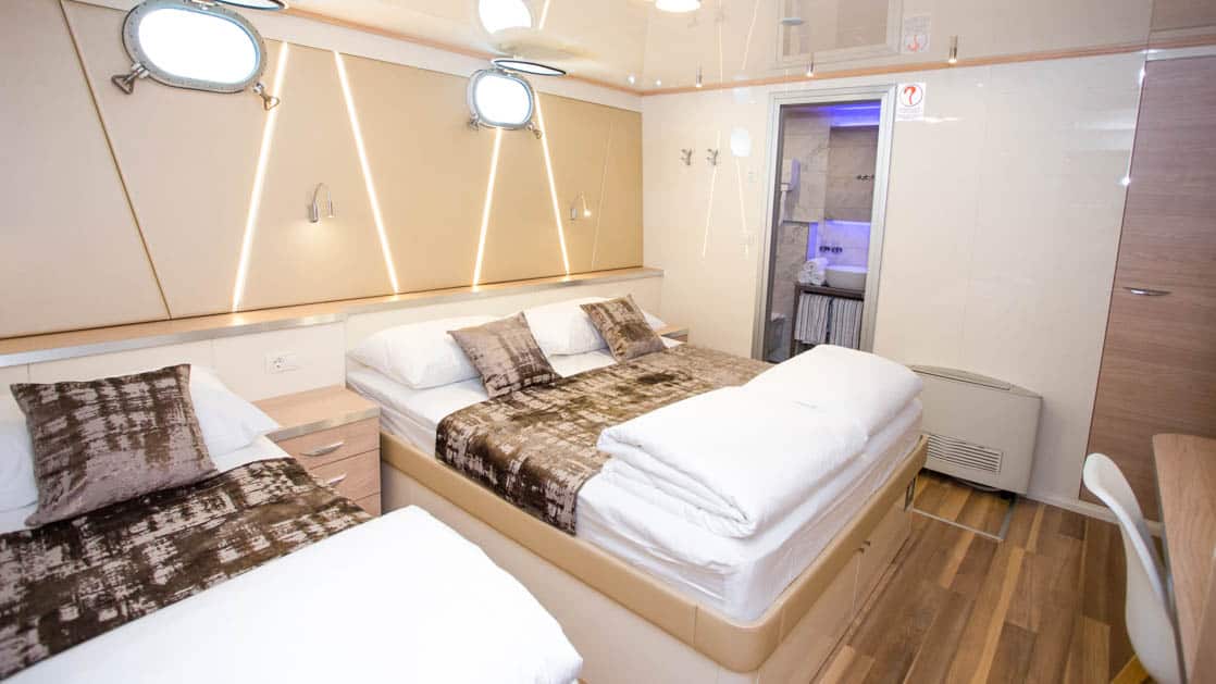 Maritimo Lower Deck cabin with 2 double beds, 2 portholes, bathroom, nightstand and reading light.