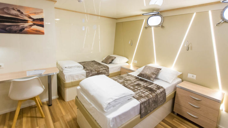 Maritimo 2 twin beds, 2 portholes, desk and chair, nightstand and reading lights.