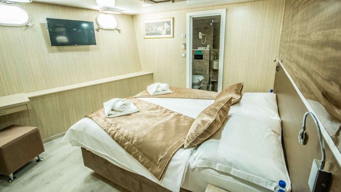 Markan Lower Deck cabin double bed, portholes, desk, bathroom and ottoman.