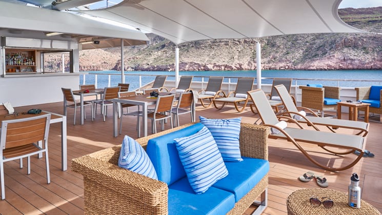 Couches, lounge chairs and tables near bar on Sun Deck of National Geographic Venture expedition ship