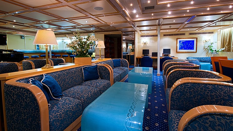 Lounge area of Corinthian small ship in Mediterreanan with couches and tables.
