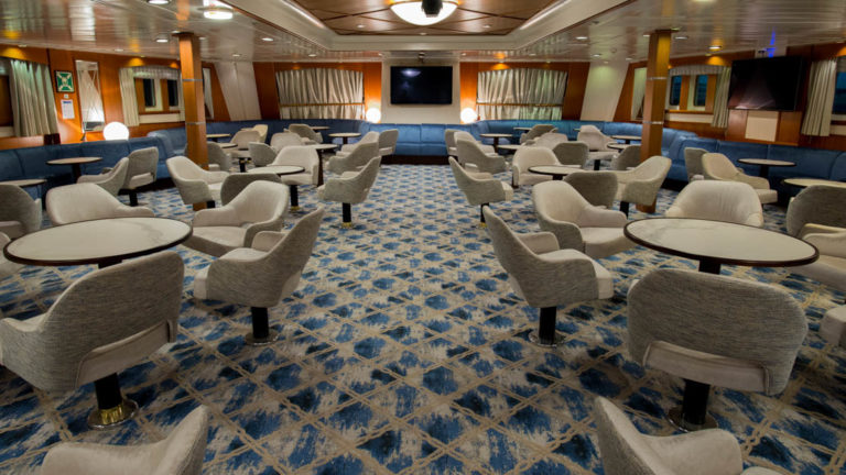 lounge area aboard Ocean Adventurer with groupings of tables and chairs