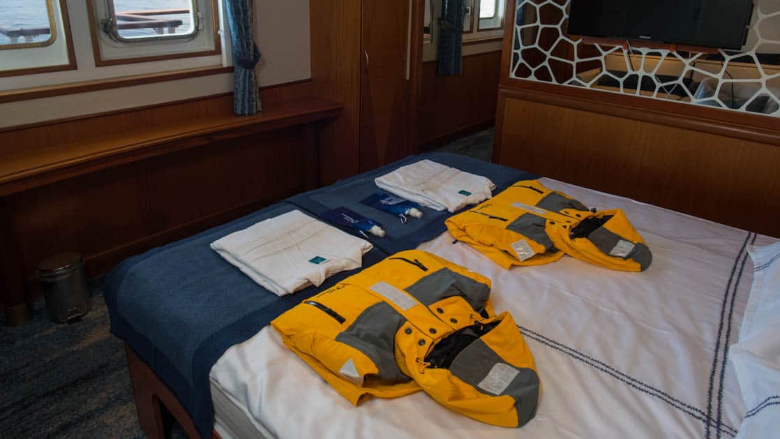 suite with large bed and jackets on the bed aboard Ocean Adventurer