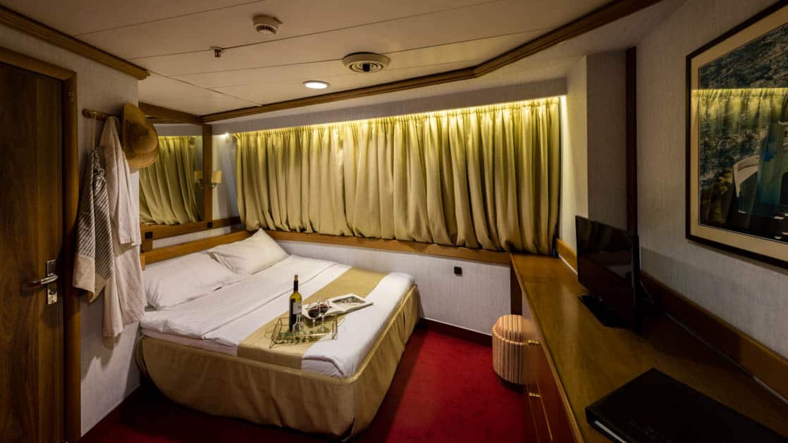 panorama luxury yacht cabin with a double bed and curtains over the large window