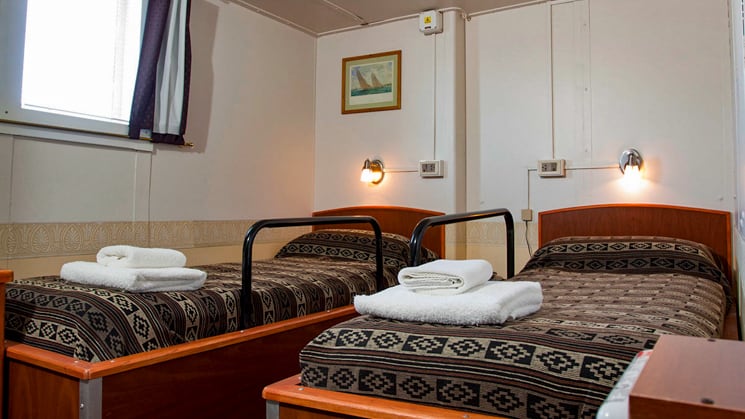Antarpply premier twin cabin with two beds and a window.