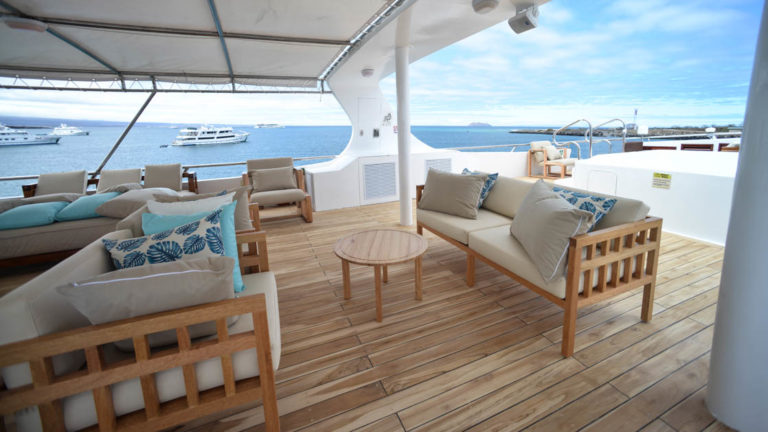 Sundeck couches with beige and blue pillows aboard Sea Star Journey Galapagos small yacht.