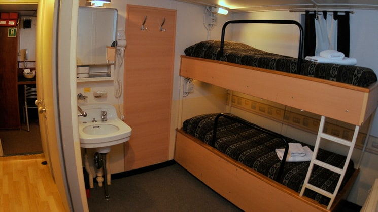 Ushuaia standard twin cabin with two twin bunk beds, sink and closet