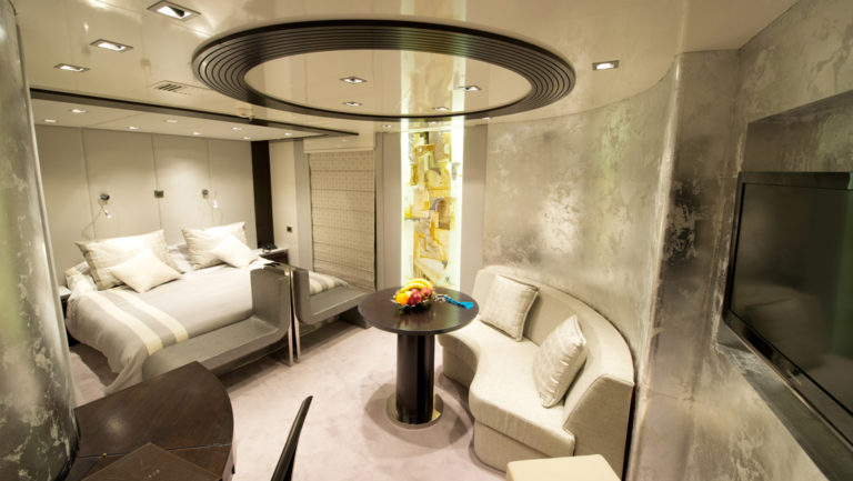 Owner's Suite with bed, sitting area, and tv aboard Variety Voyager.