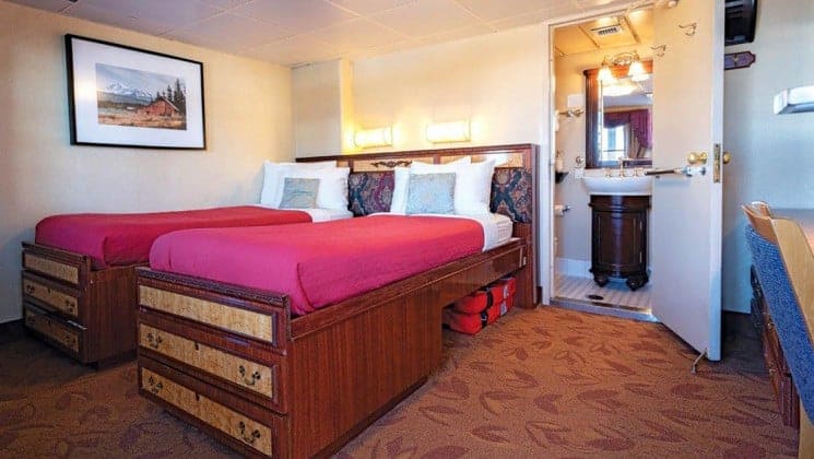 Two beds, bathroom in Admiral Stateroom aboard Wilderness Legacy expedition ship