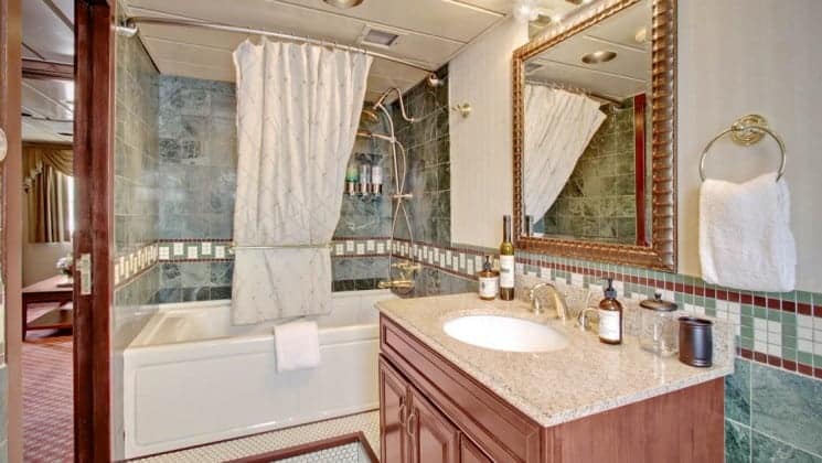 Bathroom with tub/shower, sink, mirror aboard Wilderness Legacy expedition ship