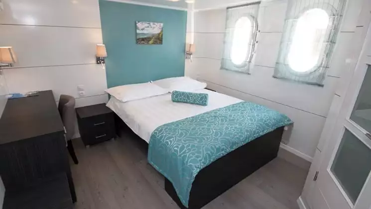 Cabin aboard Admiral with double bed and windows.