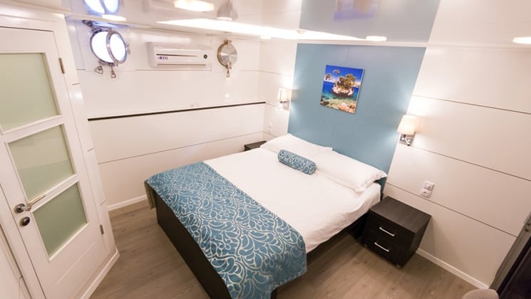 Cabin aboard Admiral with double bed and portholes.