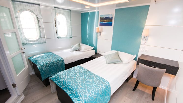 Cabin aboard Admiral with two twin beds and windows.