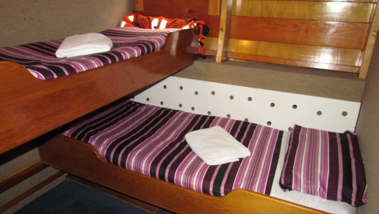 Cabin aboard Affinity with double bed and twin bed above it.