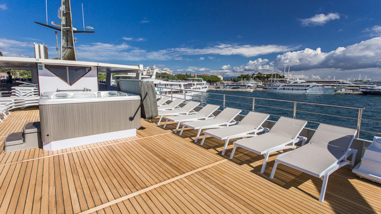 Hot tub and lounge chairs on top deck aboard Ave Maria.