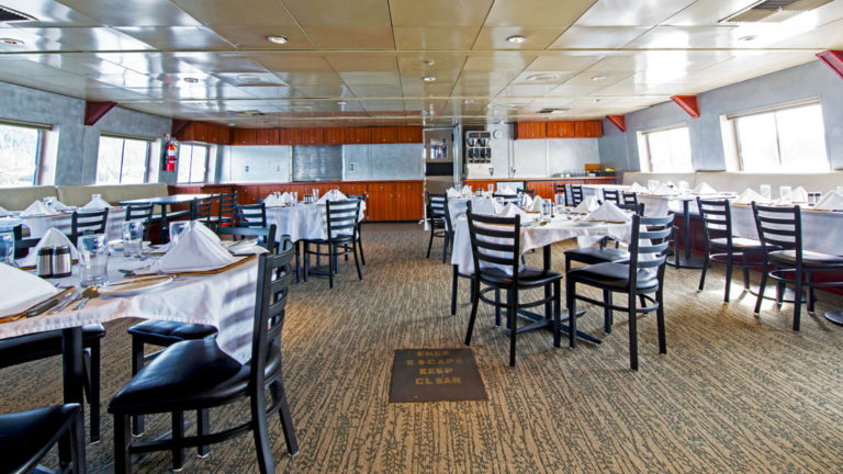 Dining room with set tables aboard Baranof Dream.