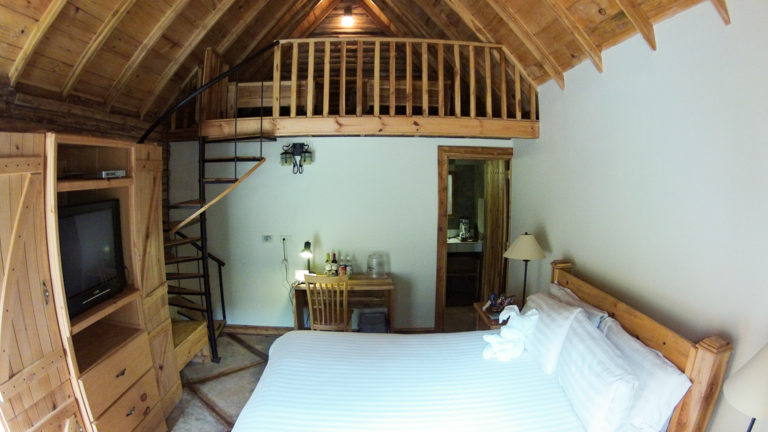 A room at Boquete Tree Trek Mountain Resort with a loft, queen bed and desk.
