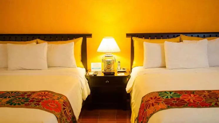 room at clarion copan hotel guatemala with two beds and a nightstand with a lamp in between them