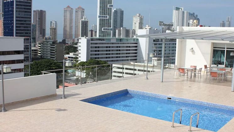 pool area on the roof of the clarion victoria panama hotel with skyscrapers all around it