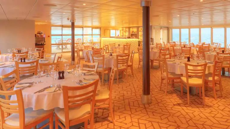 Empty dining room with many tables aboard Coral Adventurer.