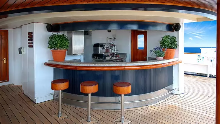 Corinthian small ship outdoor bar with stools and red door and open passageway to the deck.