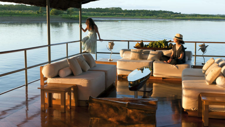 Three couches at the outdoor lounge area on the top deck aboard Delfin I on the Amazon River