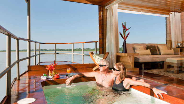 Couple in a private whirlpool outside a Deluxe Suite aboard Delfin I on the Amazon River