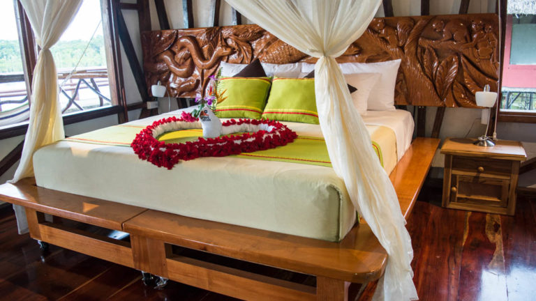 Fresh flowers are arranged on a king-sized bed with fresh drapes inside the Panoramic Suite at the Napo Wildlife Center, a luxury eco lodge surrounded by a rainforest biosphere reserve in the Ecuadorian Amazon.