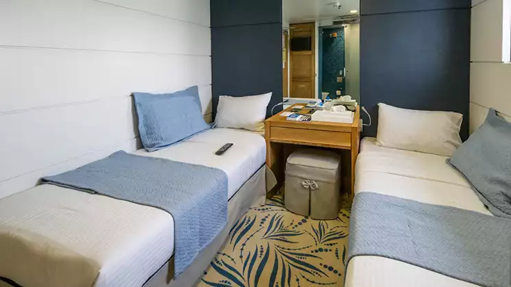 Harmony G Category B stateroom with 2 twin beds, nightstand with blue and white bedding.