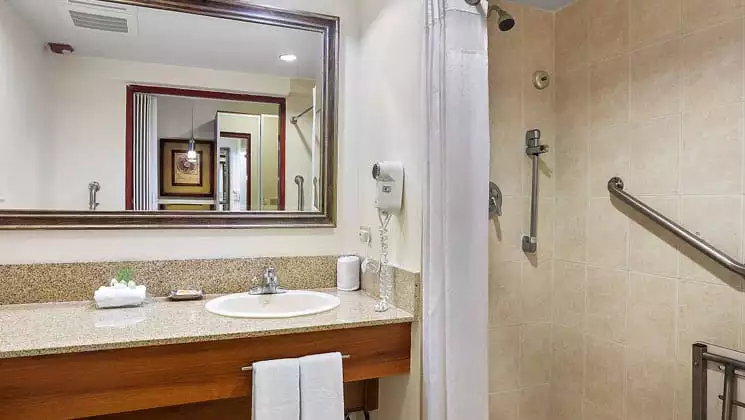 clean white bathroom with granite countertop and mirrors at the holiday inn panama canal