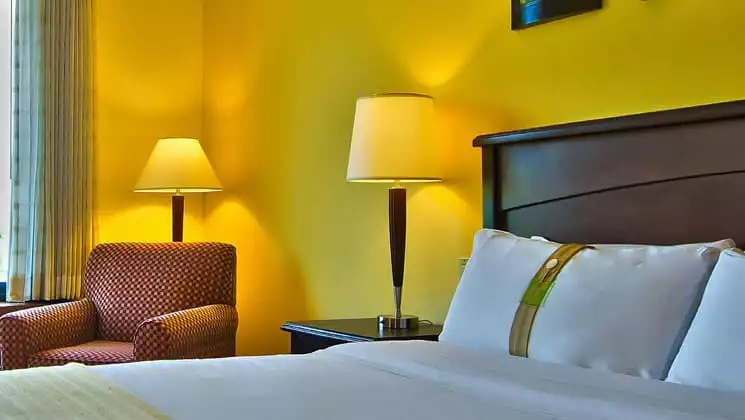 room with king bed at the holiday inn panama canal with lime green walls and two illuminated lamps