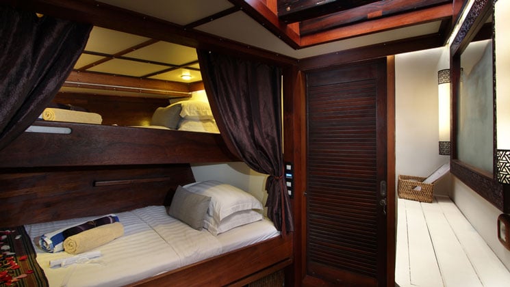Standard twin stateroom aboard Katharina sailing ship, with twin bunk beds in rich mahogany.