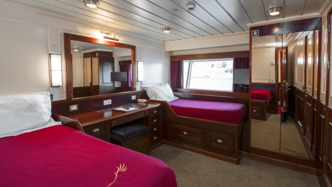 Lord of the Glens Category 2 stateroom with 2 twin beds, dresser, closet, reading lights and large window.
