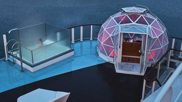 Glass geodesic dome with purple interior lighting sits beside a glass-walled small pool on deck of National Geographic Endurance.