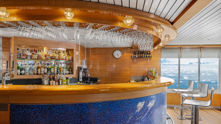 While in the Antarctic you have the full services of a beautiful wooden bar with blue accents on the National Geographic Explorer