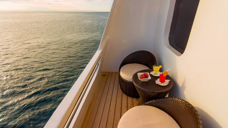 Upper Deck Suite balcony with small table and 2 chairs aboard Natural Paradise Galapagos small ship