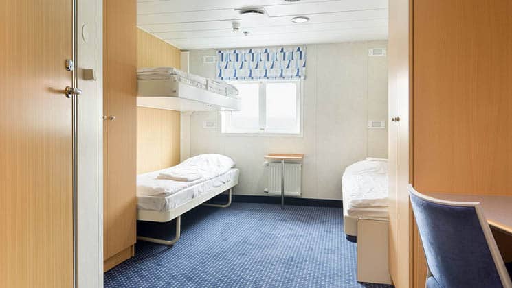 Triple cabin aboard Ocean Nova with 3 beds, a stool, window and cabinet
