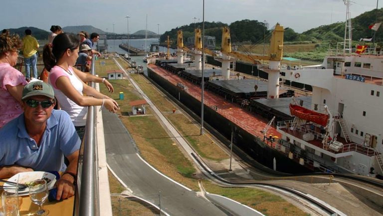 adventure travelers relax and watch small ships travel through the miraflores locks during the Panama Discovery land tour