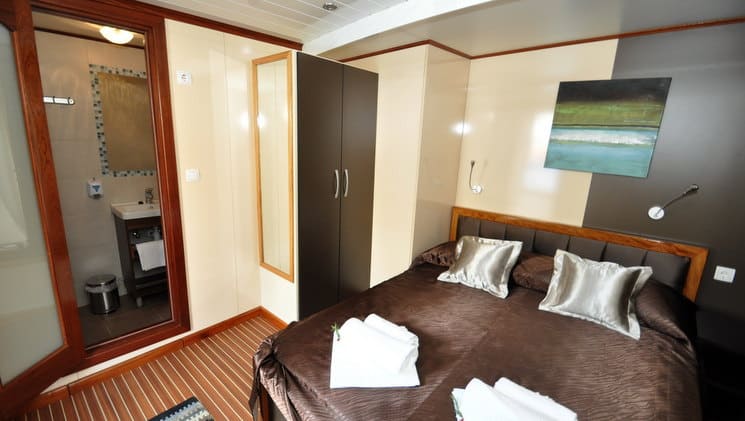 large bed with pillows and towels on it in a cabin aboard the president mediterranean luxury yacht
